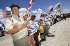 Glen Spencer, left, of the American Border Patrol, links arms with other supports of strict border enforcement during a demonstration Saturday in Palominas, Ariz. The group called on politicians to enforce the law along the border. (Pat Shannahan/ The Arizona Republic)