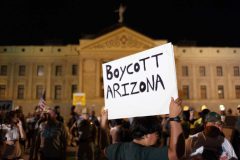 Phoenix, Arizona, USA-- A protester holds a sign calling for a Boycott of Arizona while rallying outside the Arizona state capitol against Arizona's new immigration law.  (Pat Shannahan/ The Arizona Republic)