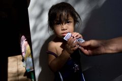 leaving0627 Alondra Rosario, 21 months, holds her Arizona ID card. She is a U.S. citizen and her family got her the id card before moving to PA.  (Pat Shannahan/ The Arizona Republic)