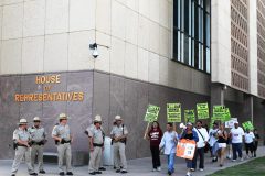 sb1070  7/28/10-A group of anti-SB1070 activists walk past a group of law enforcement officers outside the Arizona House of Representatives Wednesday afternoon. (Pat Shannahan/ The Arizona Republic)