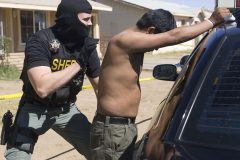 6/3/08- A Maricopa County Sheriff's deputy searches an illigal immigrant found in a drop house in west Phoenix. Detectives determined that the man was one of three possible smugglers in the house.  (Pat Shannahan/ The Arizona Republic)